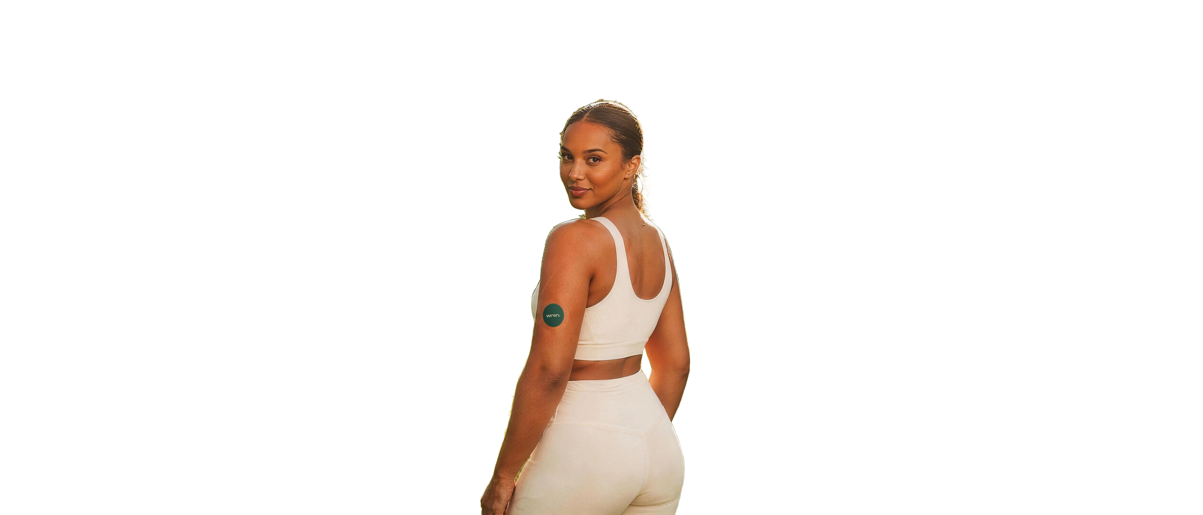 Woman in a sunlit park wearing a Wren glucose sensor on the back of her upper arm